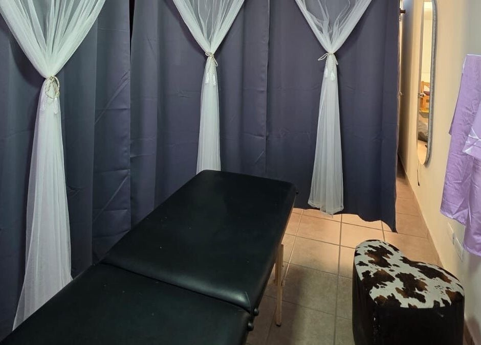 Sala de masajes en Lume Lys, Durango, Durango, MX con cortinas elegantes y camilla negra.