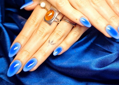 Bright blue manicure on a hand at Poise & Polish Beauty Bar in Cape Town, Western Cape, ZA.