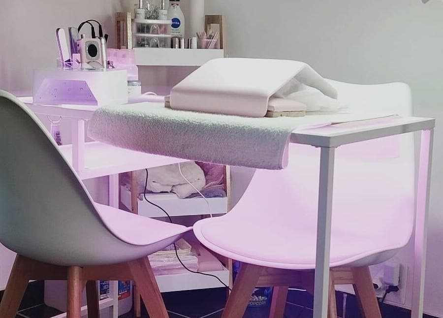 Modern nail station at Nails By Kim in Pretoria, Gauteng, ZA, featuring stylish white chairs and professional equipment.