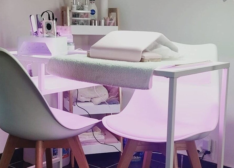 Modern nail station at Nails By Kim in Pretoria, Gauteng, ZA, featuring stylish white chairs and professional equipment.