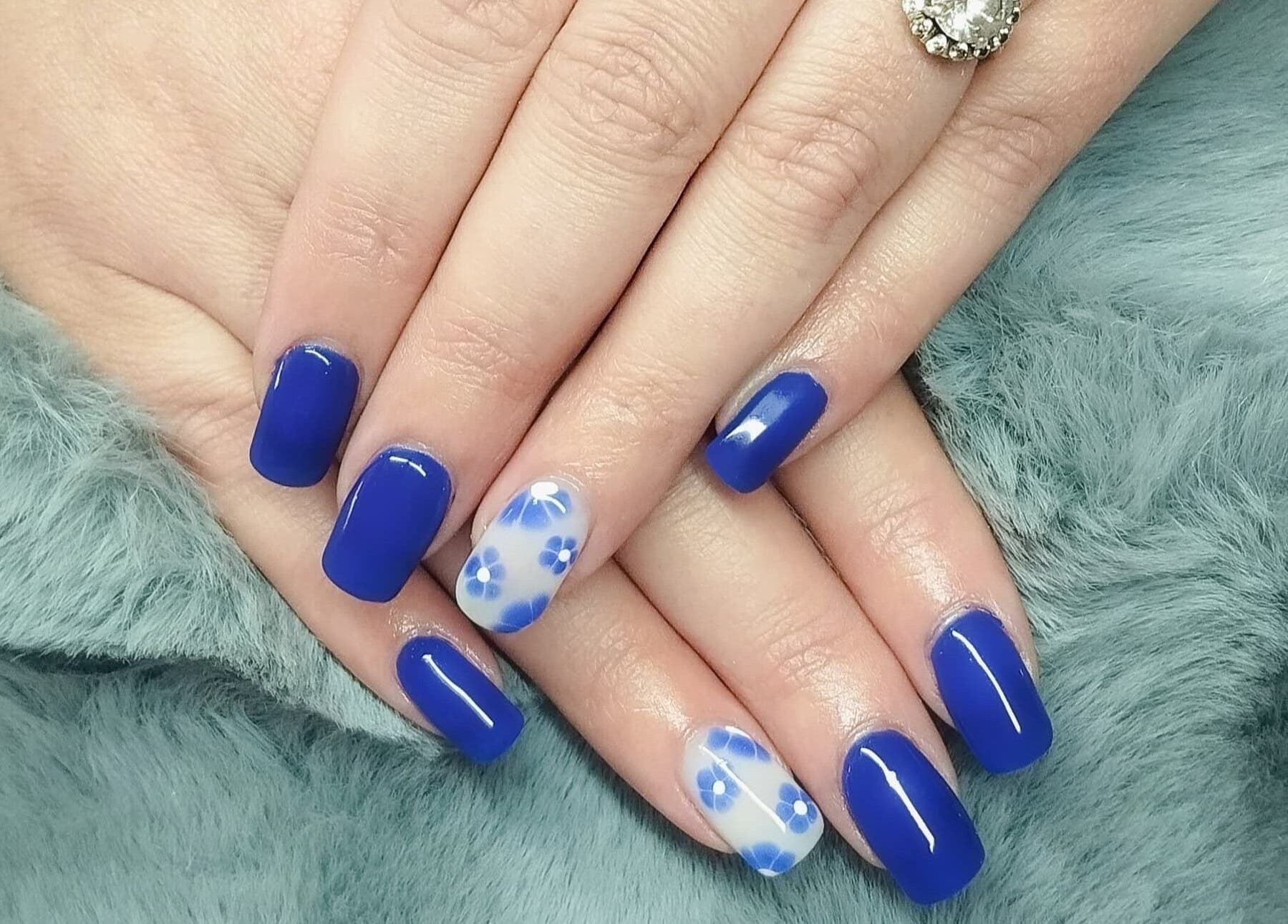 Vibrant blue floral nails from Nails By Kim, Pretoria, Gauteng, ZA. Perfectly manicured hands displayed.