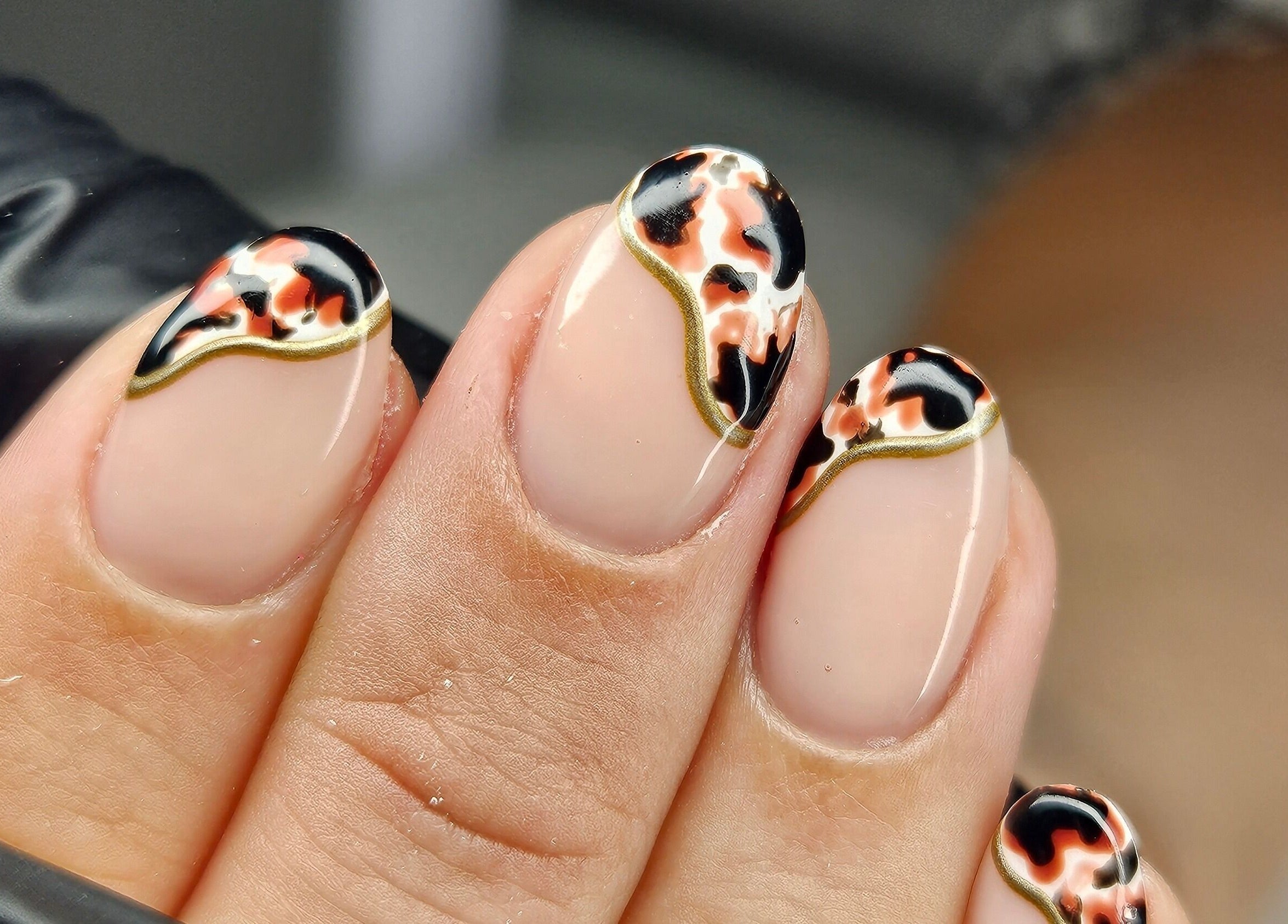 Bold tortoiseshell nail art at cwbeautyofficial in Milnrow, England, GB enhancing stylish manicure.