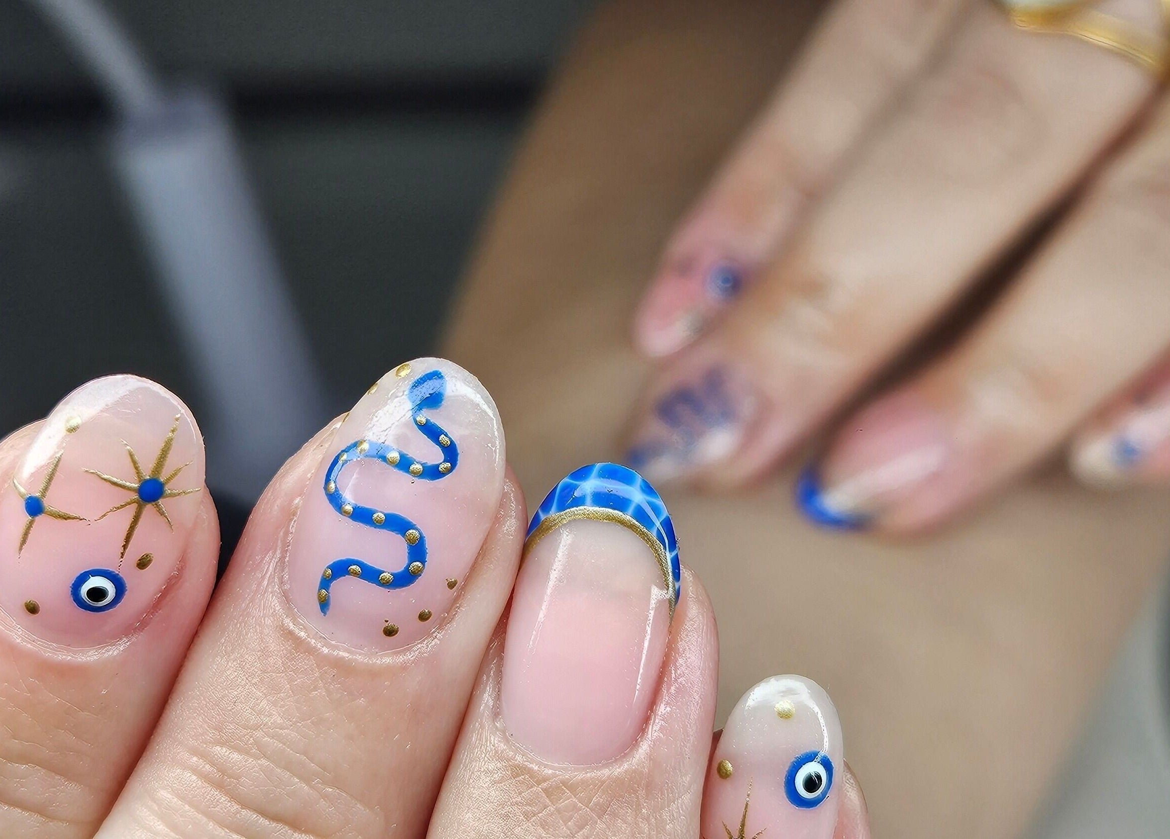 Intricate blue nail art at cwbeautyofficial, Milnrow, England, GB showcasing detailed designs.