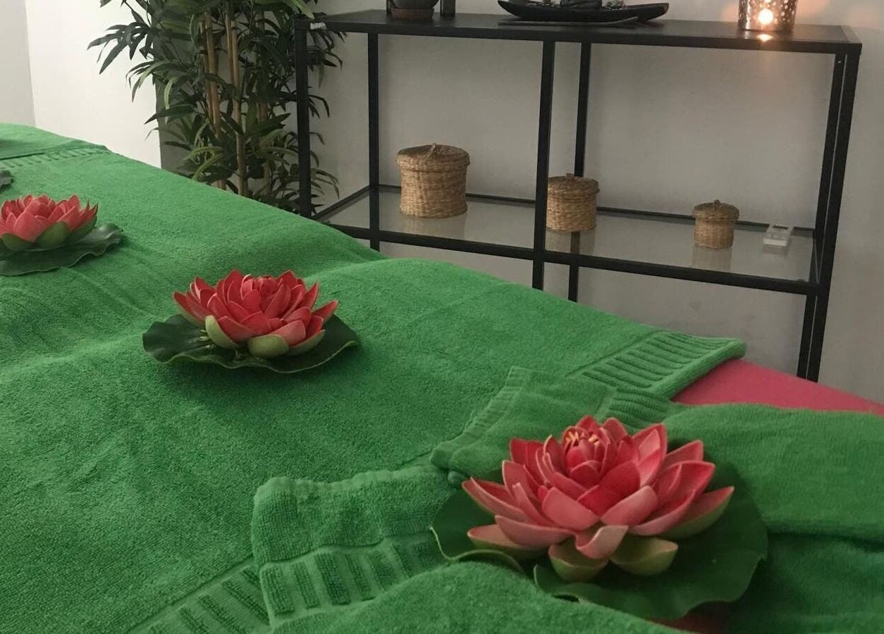 Sala de masajes en Lanzarote Massages, Costa Teguise, Canarias, ES con decoración floral y toallas verdes.