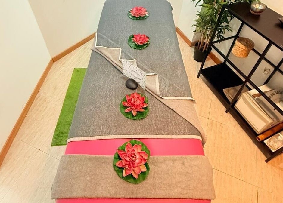 Cama de masaje decorada en Lanzarote Massages, Costa Teguise, Canarias, ES, con flores de loto.