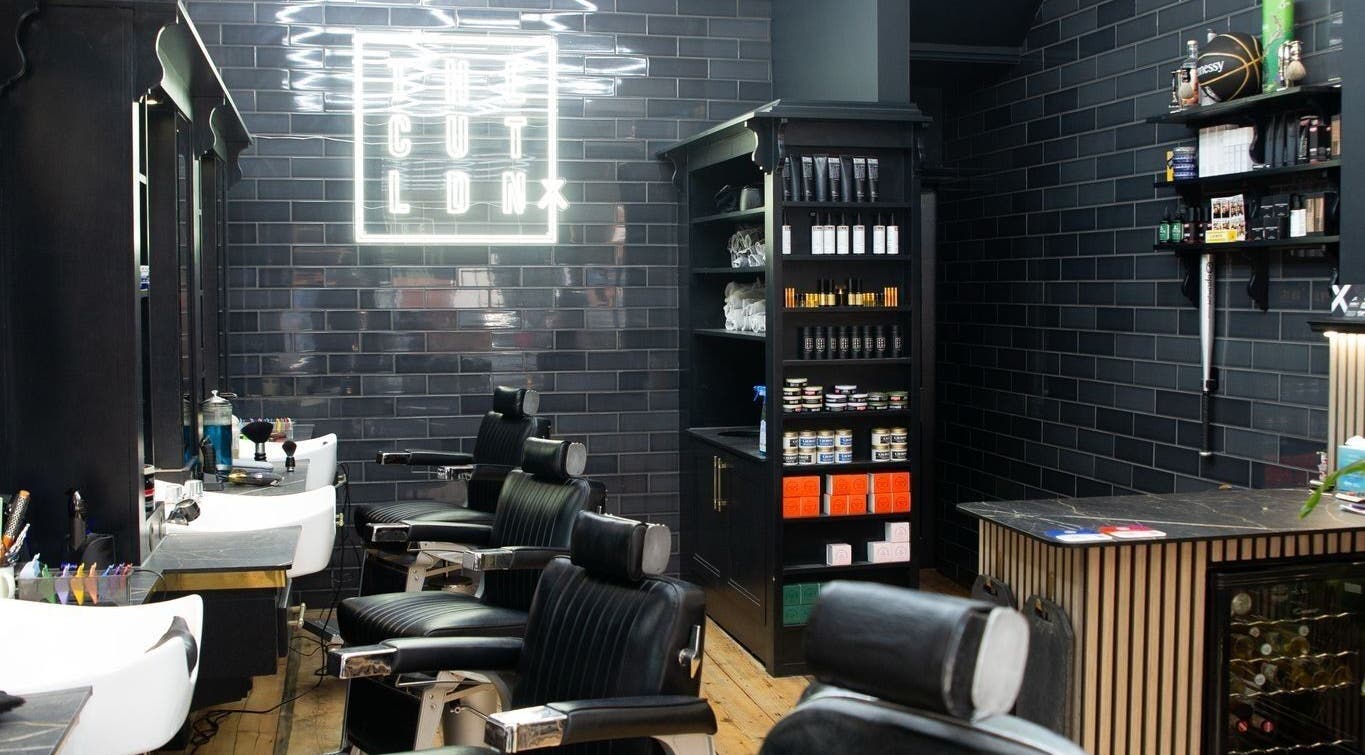 Interior of The Cut LDN barber shop in London, England, GB, featuring stylish black decor and grooming chairs.