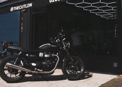 Stylish motorcycle outside The Cut LDN, barbershop in London, England, GB, inviting ambiance.