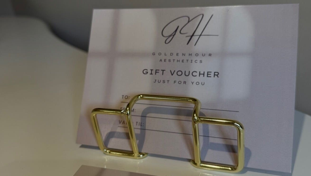 Gift voucher at Golden Hour Aesthetics, Derby, England, GB, elegantly presented with a gold holder.