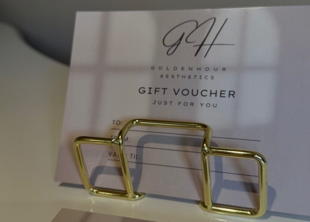 Gift voucher at Golden Hour Aesthetics, Derby, England, GB, elegantly presented with a gold holder.