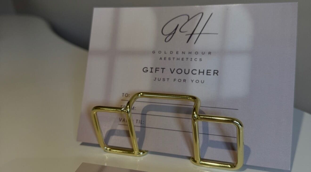 Gift voucher at Golden Hour Aesthetics, Derby, England, GB, elegantly presented with a gold holder.