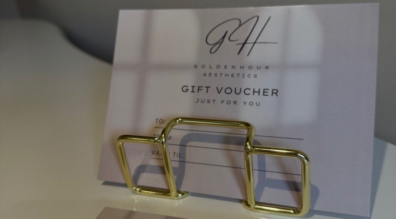 Gift voucher at Golden Hour Aesthetics, Derby, England, GB, elegantly presented with a gold holder.