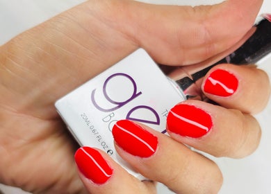Vibrant red nails with nail polish bottle at Solely Elegant, Thornaby, England, GB.