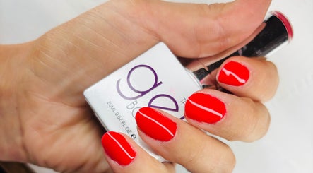 Vibrant red nails with nail polish bottle at Solely Elegant, Thornaby, England, GB.