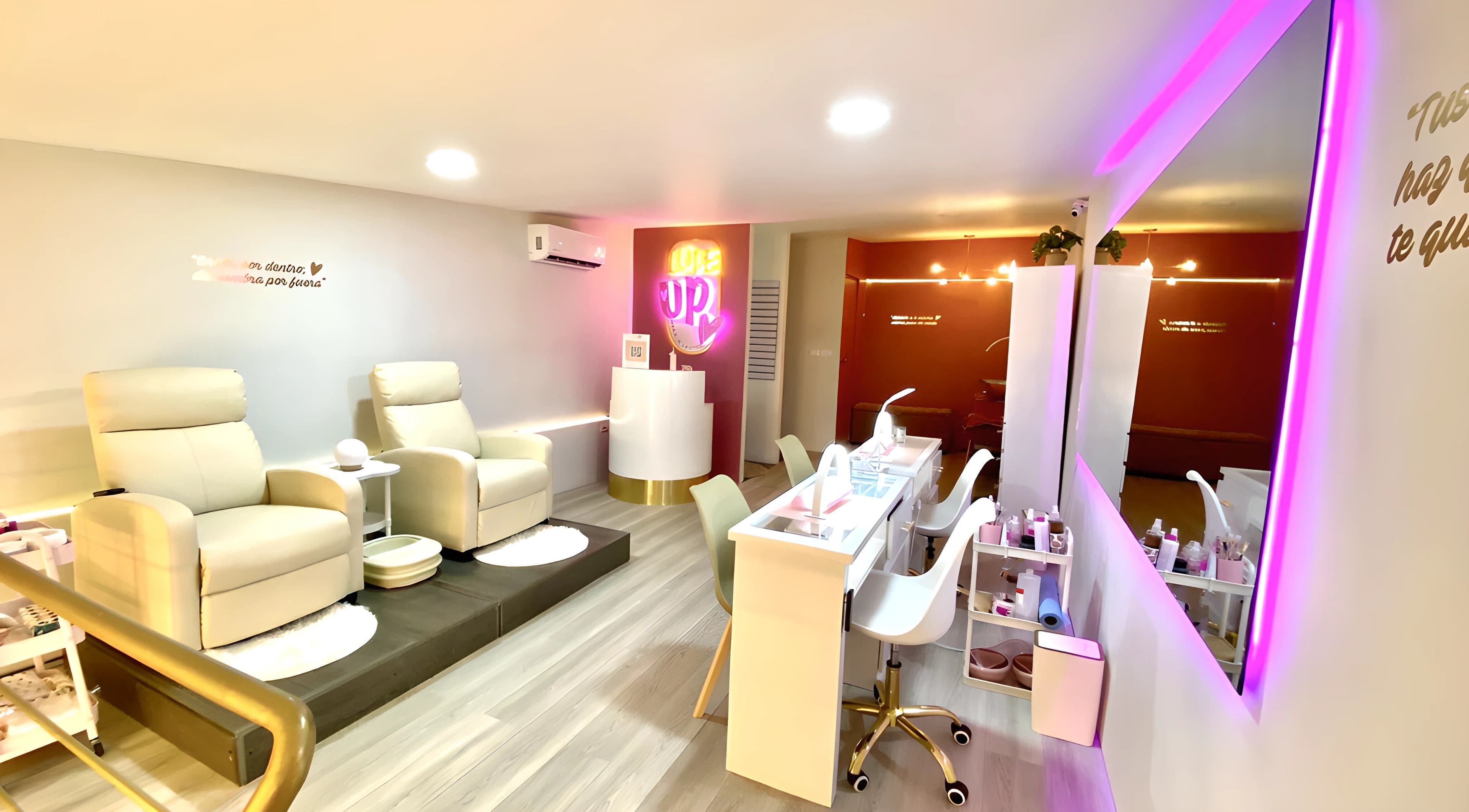 Interior elegante de `Love Up` en Villahermosa, Tabasco, MX, mostrando cómodas sillas y mesas de belleza.