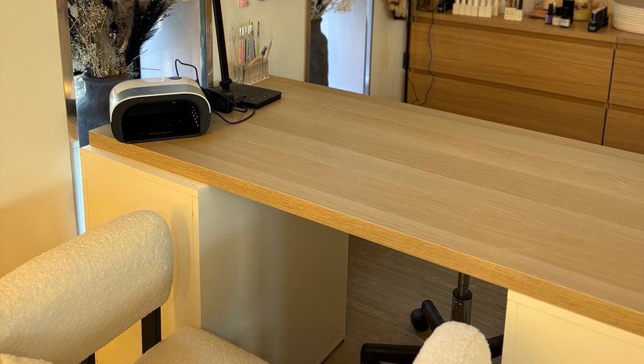 Nail station at Macie Jones Studios, Aberdare, Wales, GB, featuring manicure tools on a wooden desk.