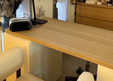 Nail station at Macie Jones Studios, Aberdare, Wales, GB, featuring manicure tools on a wooden desk.