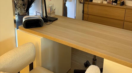 Nail station at Macie Jones Studios, Aberdare, Wales, GB, featuring manicure tools on a wooden desk.