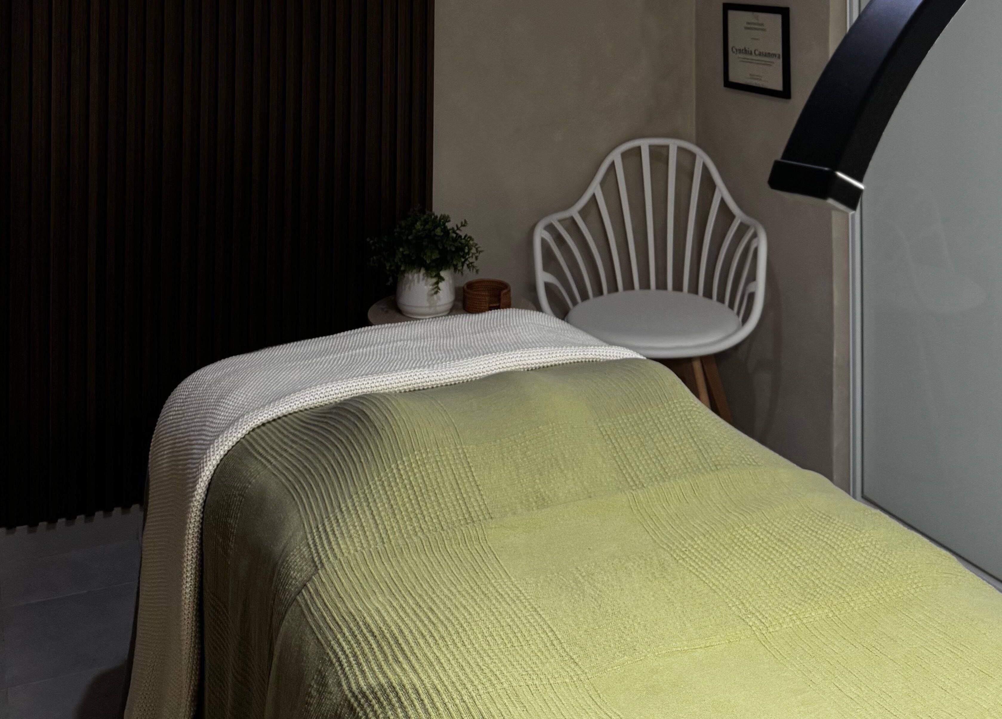 Una habitación de spa en Kare Esthetics, Bayamón, Puerto Rico, PR, con cama verde y silla blanca.