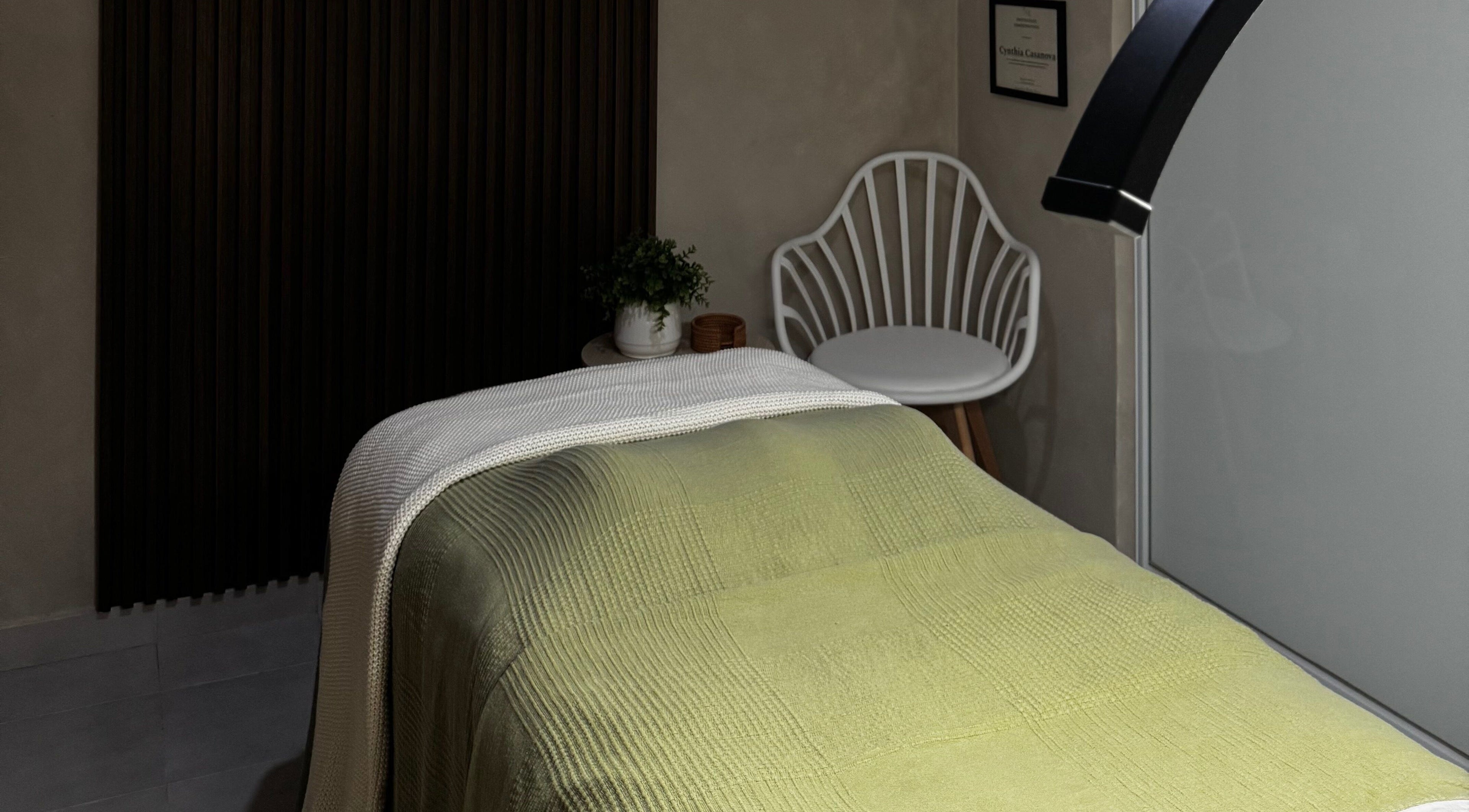 Una habitación de spa en Kare Esthetics, Bayamón, Puerto Rico, PR, con cama verde y silla blanca.