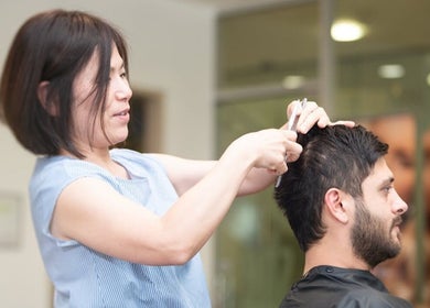 Stylist at She hairdressing in Melbourne, Victoria, AU expertly cuts a client's hair.