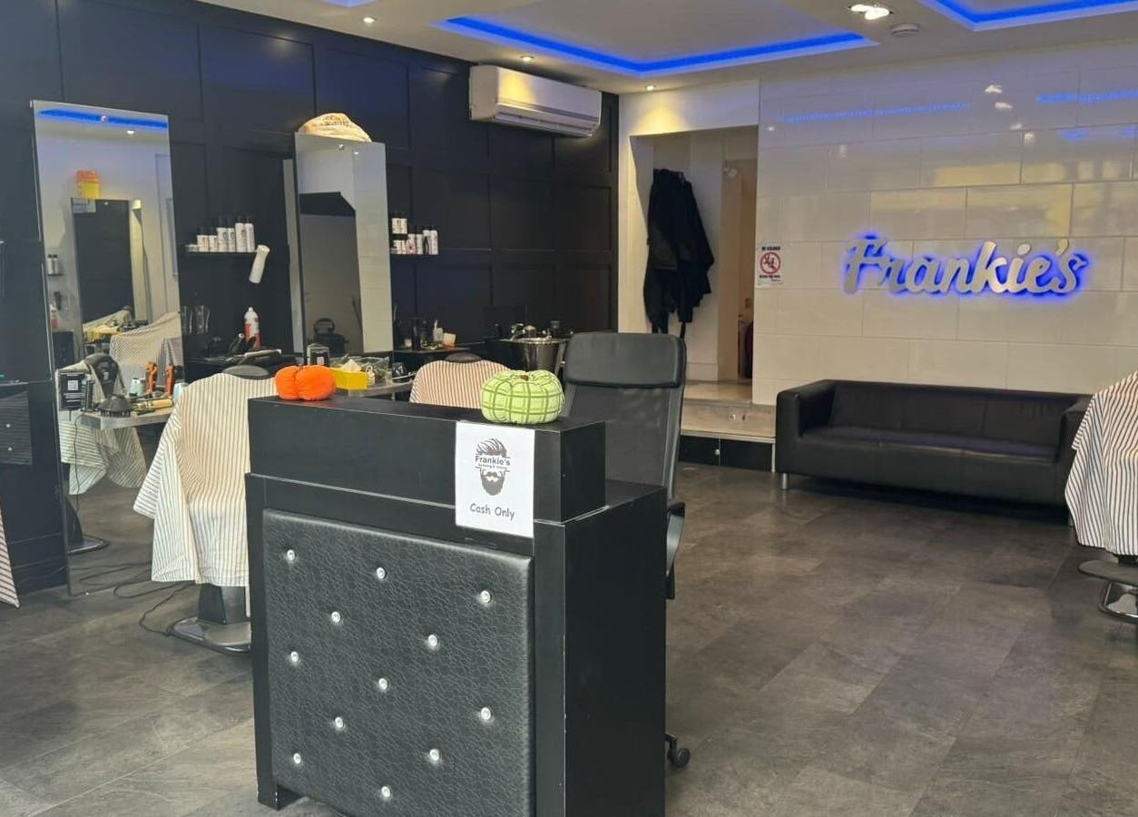 Modern interior of Frankies Barbers & Tanning in Biggleswade, England, GB, featuring barber chairs and stylish decor.