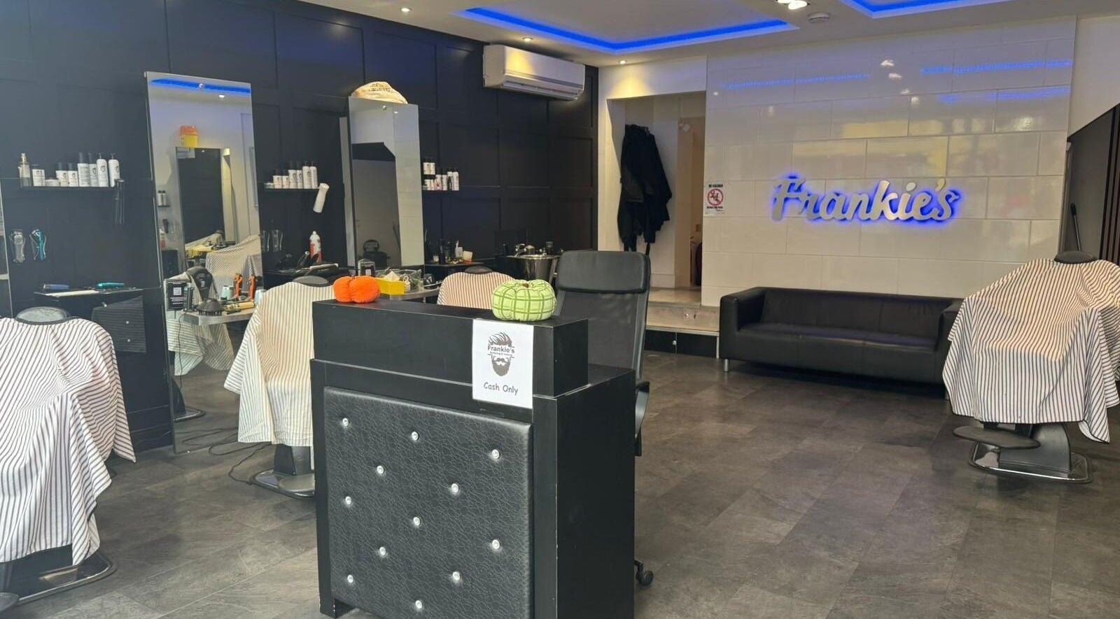 Modern interior of Frankies Barbers & Tanning in Biggleswade, England, GB, featuring barber chairs and stylish decor.