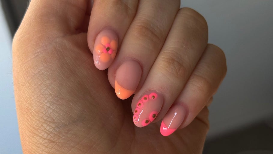 Elegant nail art design featuring pink and orange florals at Byellaofm in Birmingham, England, GB.