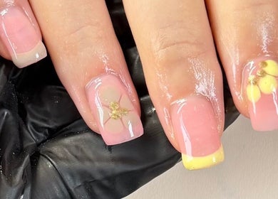 Elegant floral nail art at Byellaofm, Birmingham, England, GB, featuring delicate yellow and gold accents.