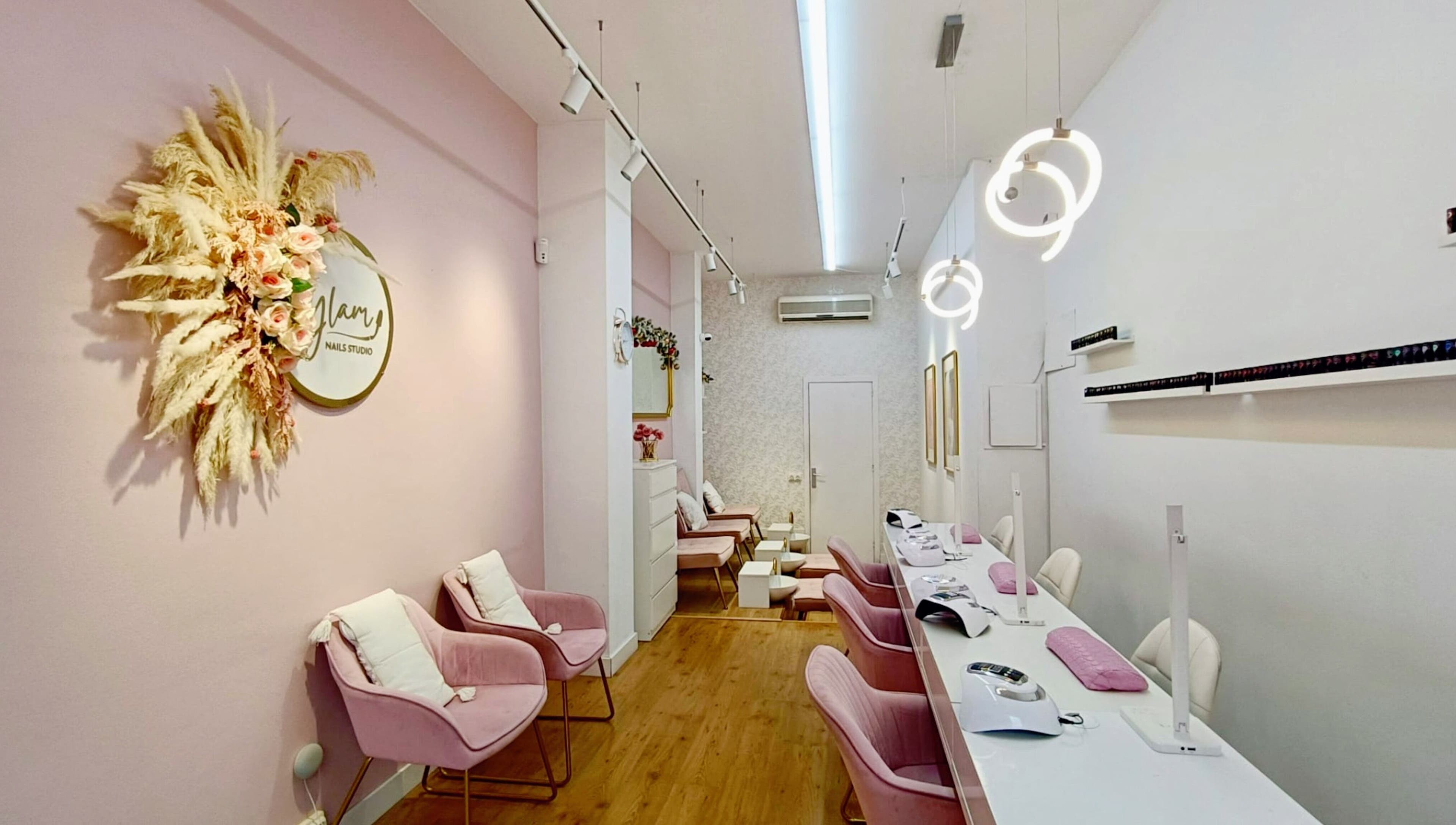 Interior tranquilo de GLAM Nails Studio - Guillem Tell en Barcelona, Catalunya, ES, con sillas rosadas elegantes.