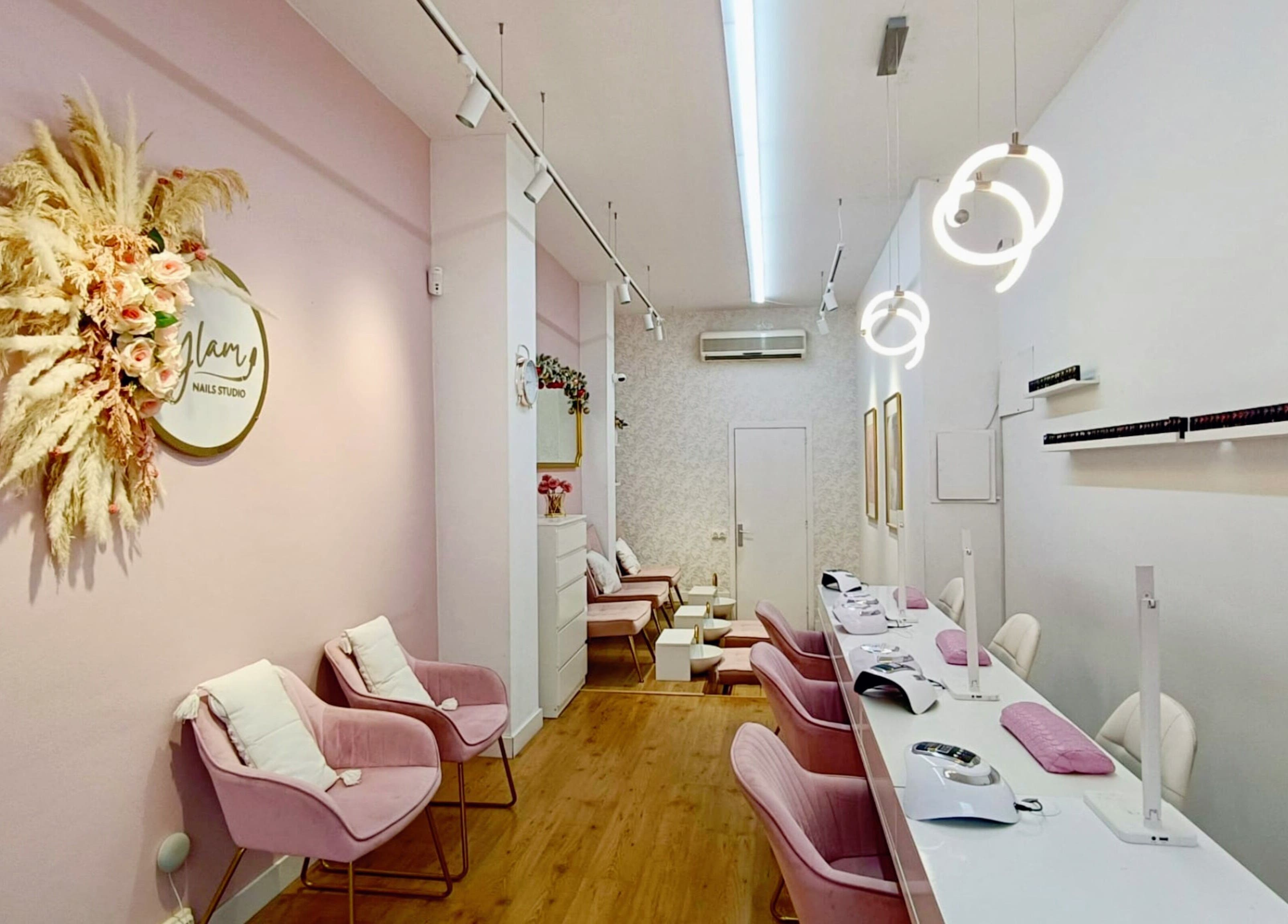 Interior tranquilo de GLAM Nails Studio - Guillem Tell en Barcelona, Catalunya, ES, con sillas rosadas elegantes.