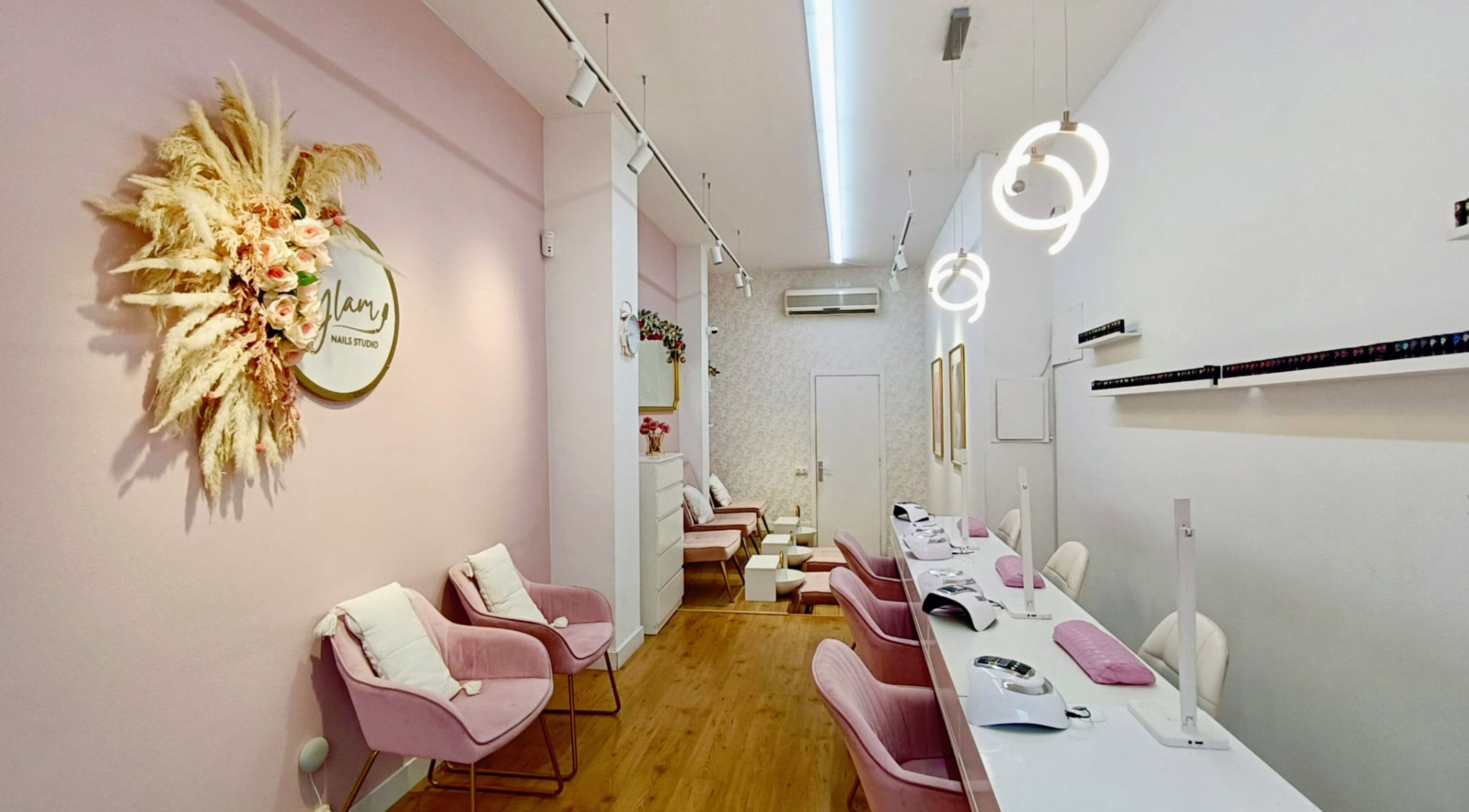 Interior tranquilo de GLAM Nails Studio - Guillem Tell en Barcelona, Catalunya, ES, con sillas rosadas elegantes.