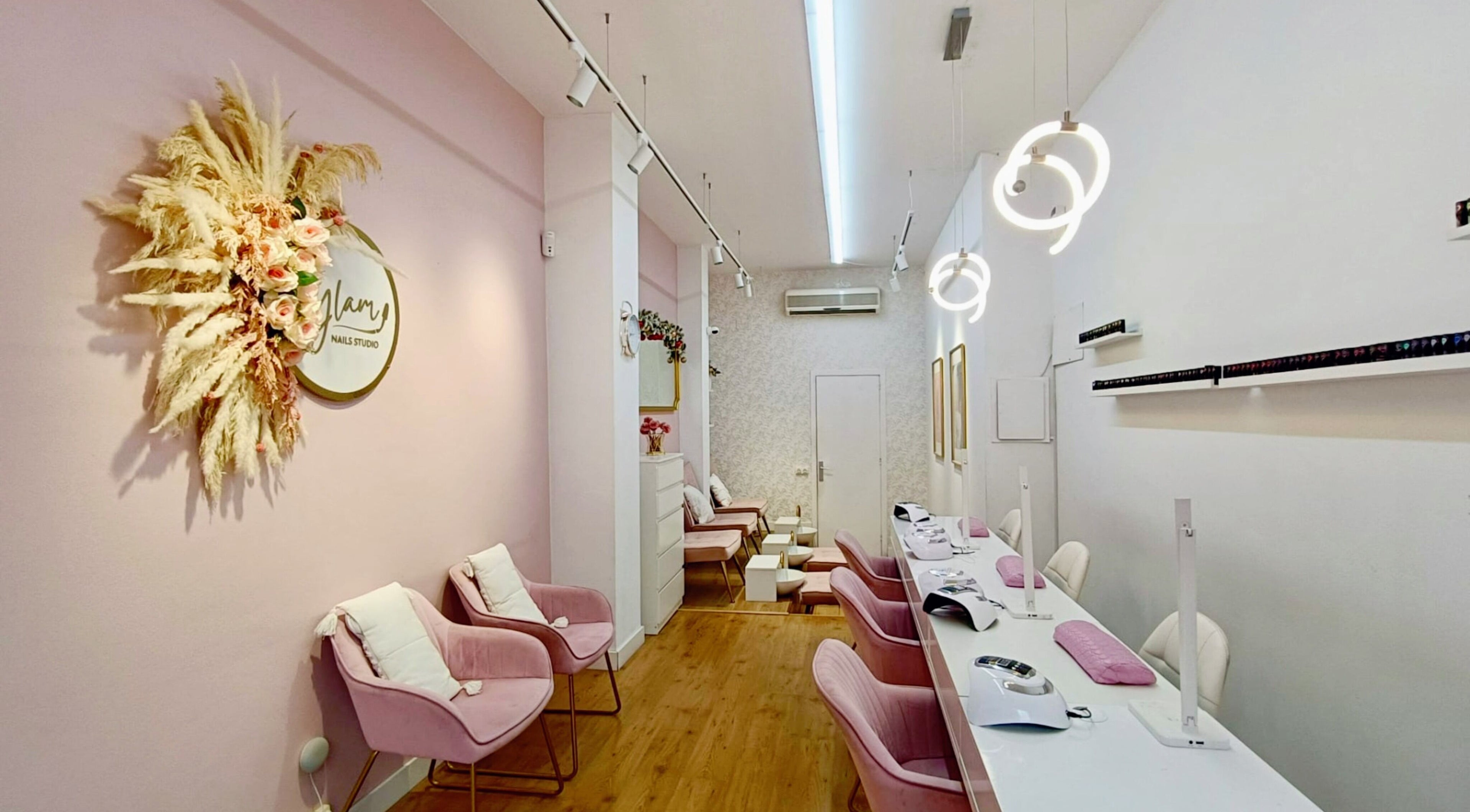 Interior tranquilo de GLAM Nails Studio - Guillem Tell en Barcelona, Catalunya, ES, con sillas rosadas elegantes.