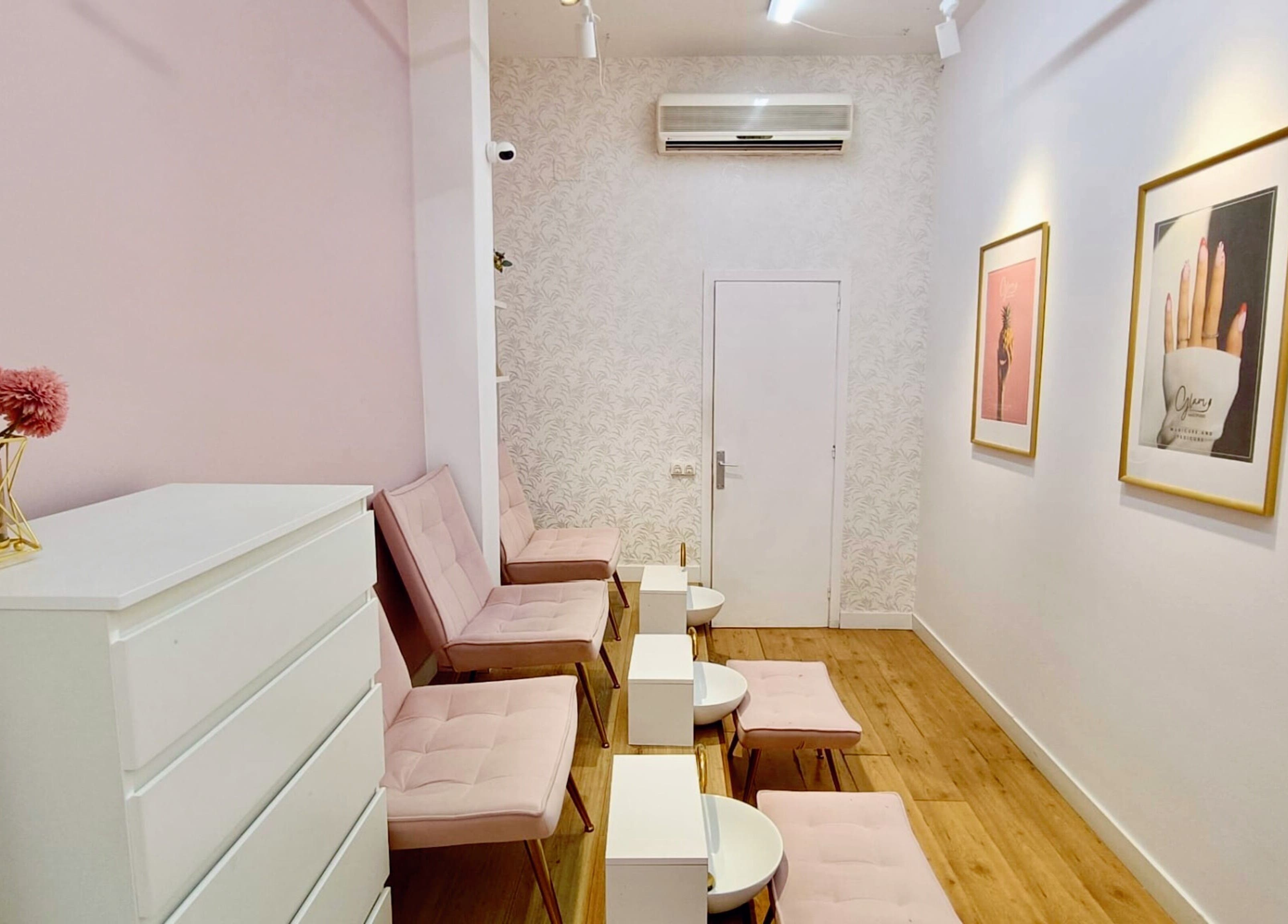 Espacio elegante en GLAM Nails Studio - Guillem Tell, Barcelona con sillas rosas y decoraciones chic.