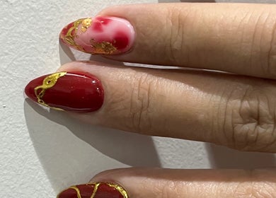 Elegant red and gold nail art at PRESH’S NAIL BAR in Pretoria, Gauteng, ZA, showcasing exquisite craftsmanship.