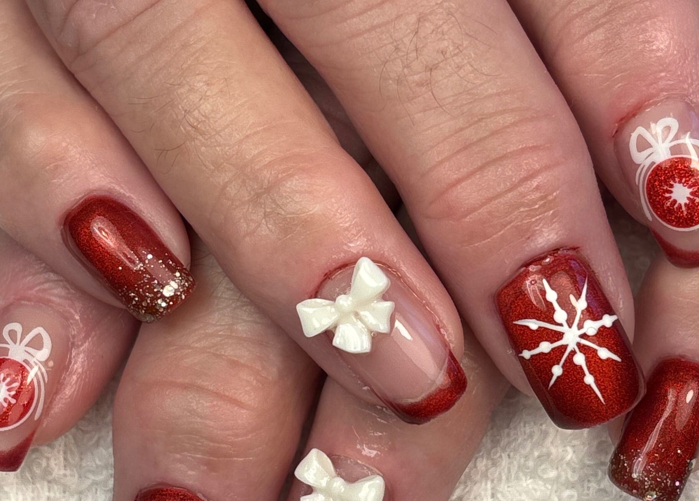 Nail art de Noël chez Art&Miss, Chartainvilliers, Centre-val De Loire, FR. Design rouge brillant avec décorations.