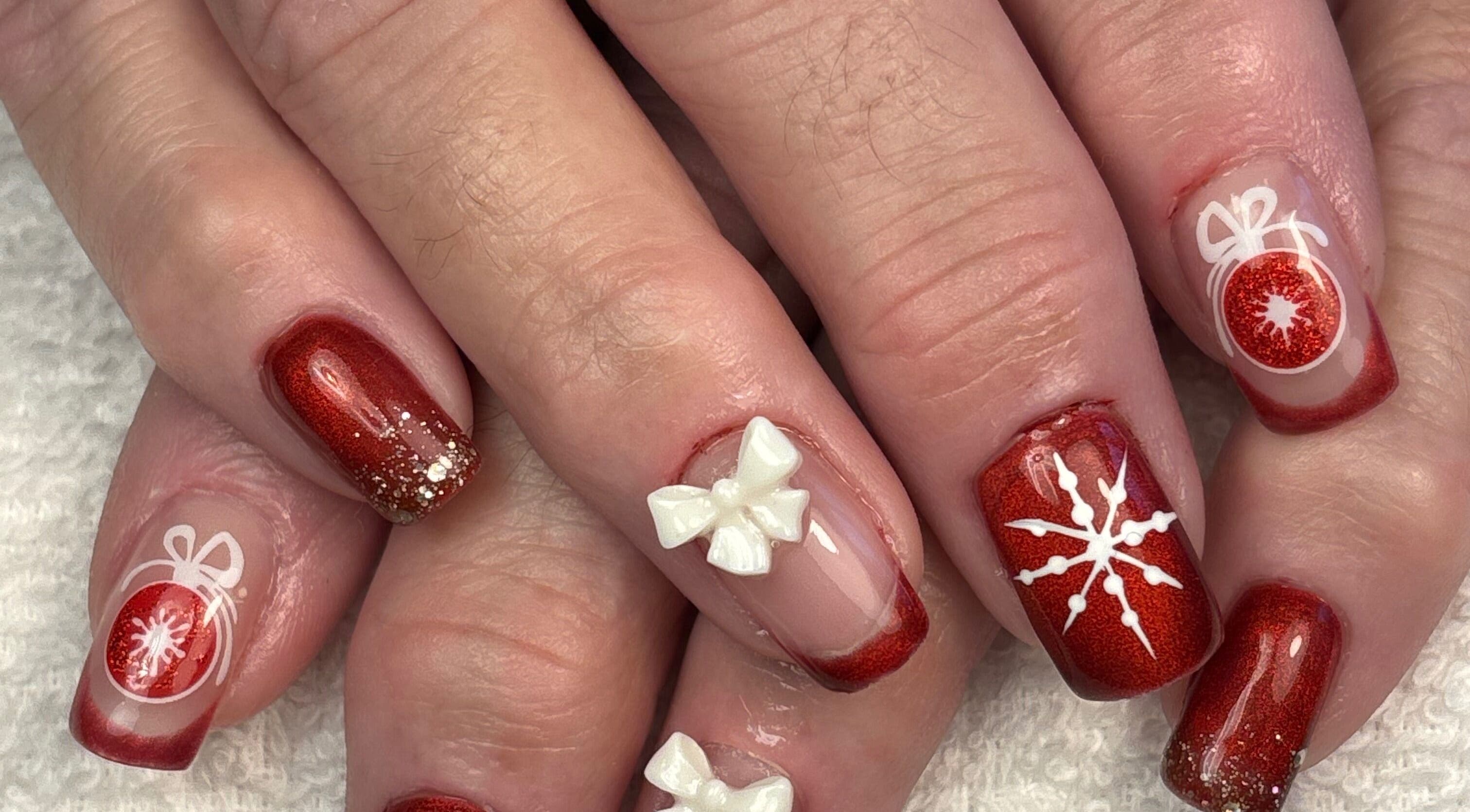 Nail art de Noël chez Art&Miss, Chartainvilliers, Centre-val De Loire, FR. Design rouge brillant avec décorations.