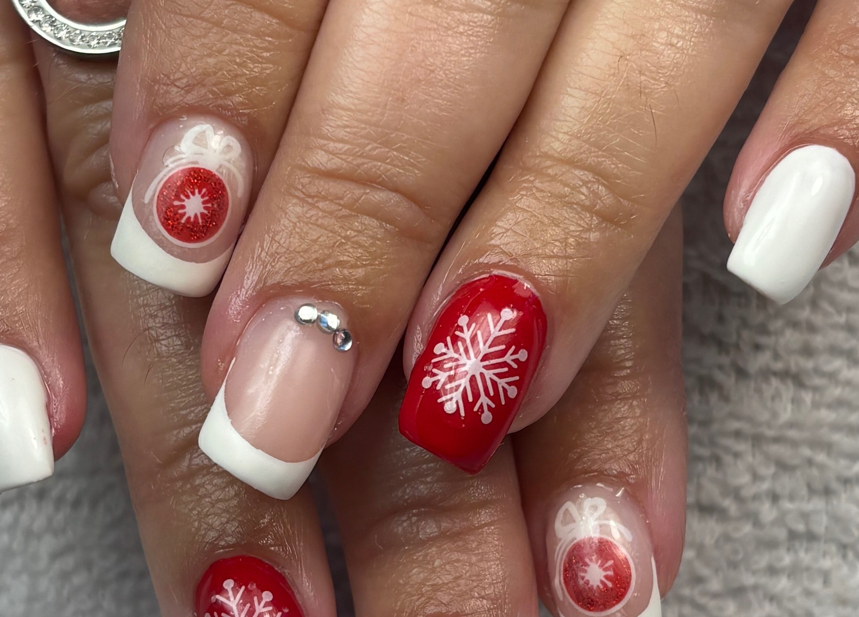 Nail art festive avec flocons et couleurs vives à Art&Miss, Chartainvilliers, Centre-val De Loire, FR.