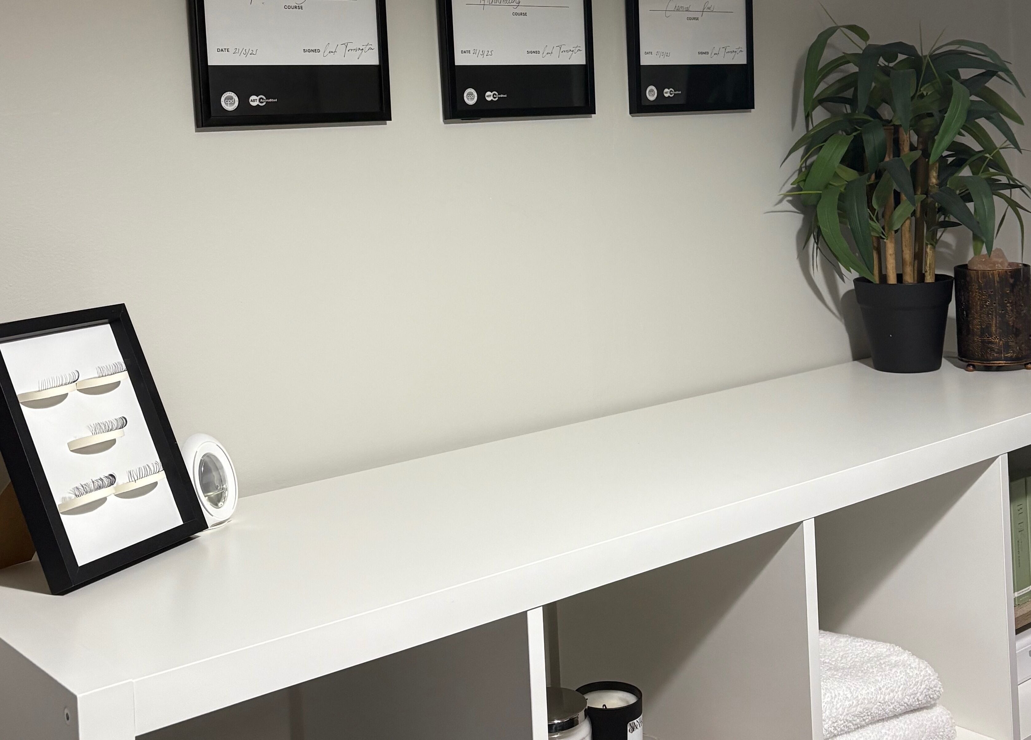 EnvyStudio's modern display shelf with framed lashes and decor, located in Banstead, England, GB.
