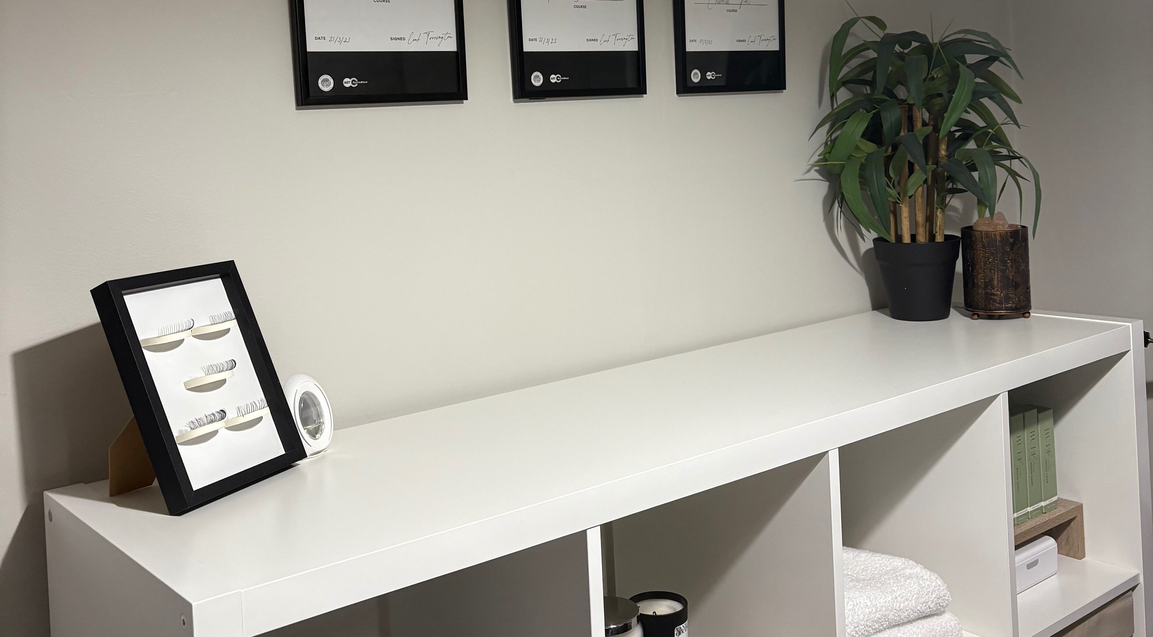 EnvyStudio's modern display shelf with framed lashes and decor, located in Banstead, England, GB.