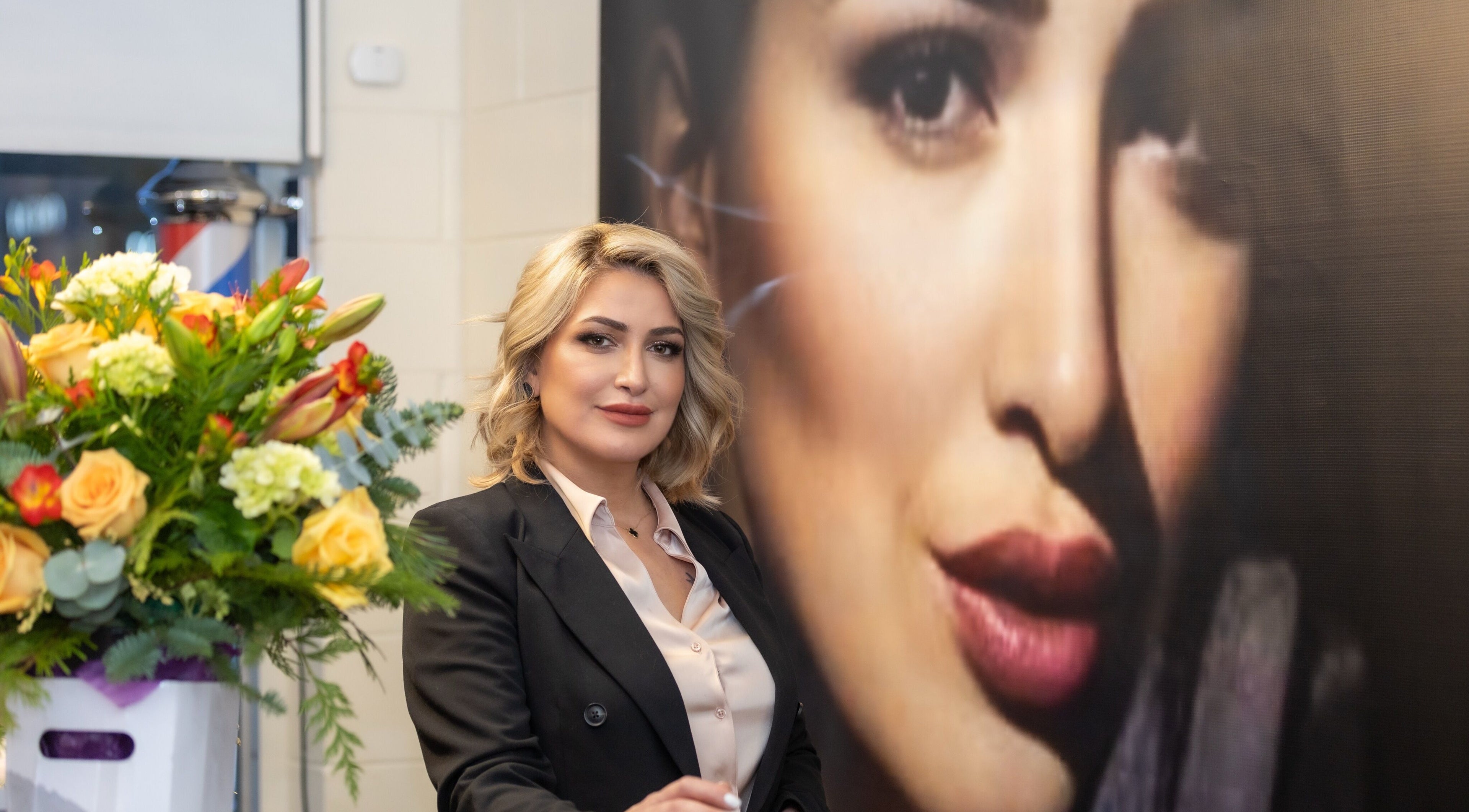 Interior of Avante Salon & Spa, Grimsby, Ontario, CA with a stylish woman and vibrant floral arrangement.