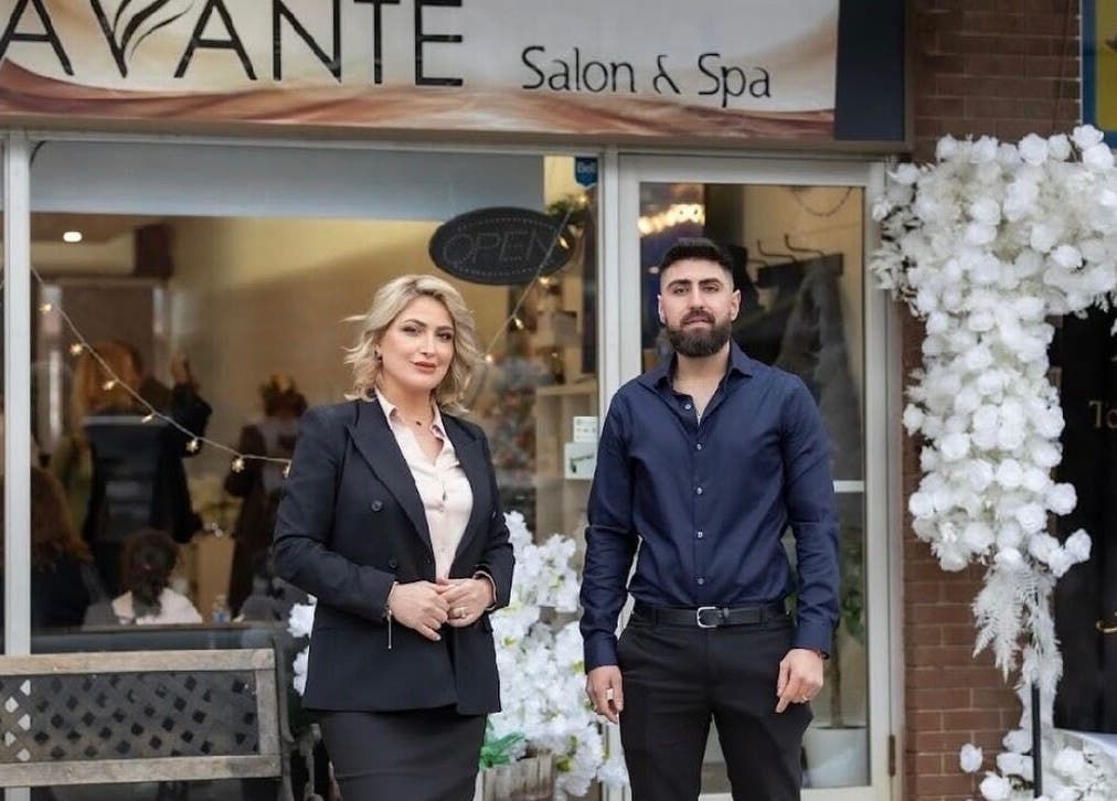 Owners of Avante Salon & Spa in Grimsby, Ontario, CA stand proudly at the entrance adorned with flowers.