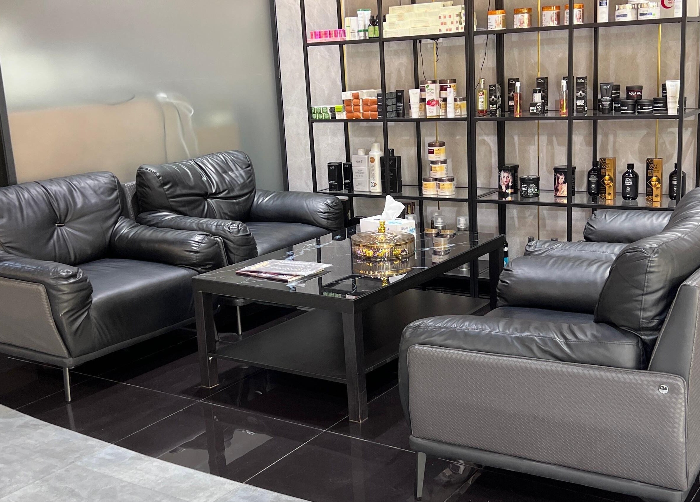 Elegant seating area at Glaymore Gents Salon in Arjan, دبي, AE with plush leather sofas and product display.