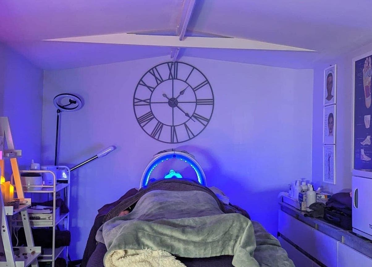 Relaxing therapy room at Reflexions, Hockley, England, GB with ambient lighting and treatment bed.