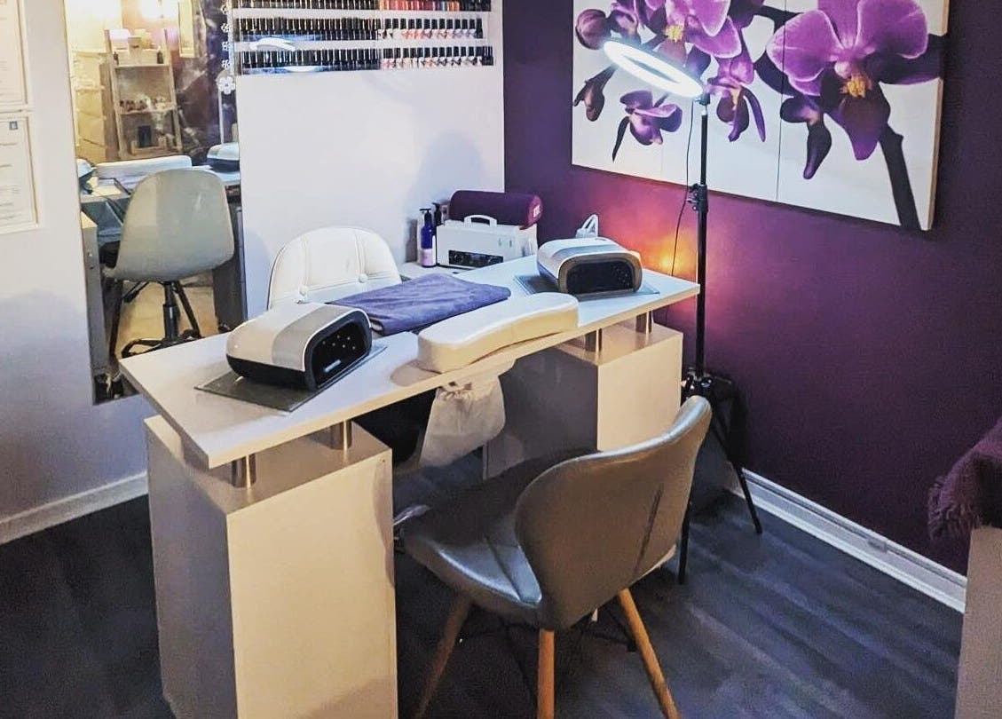 Stylish nail salon setup at Reflexions, Hockley, England, GB, featuring purple floral decor and modern equipment.