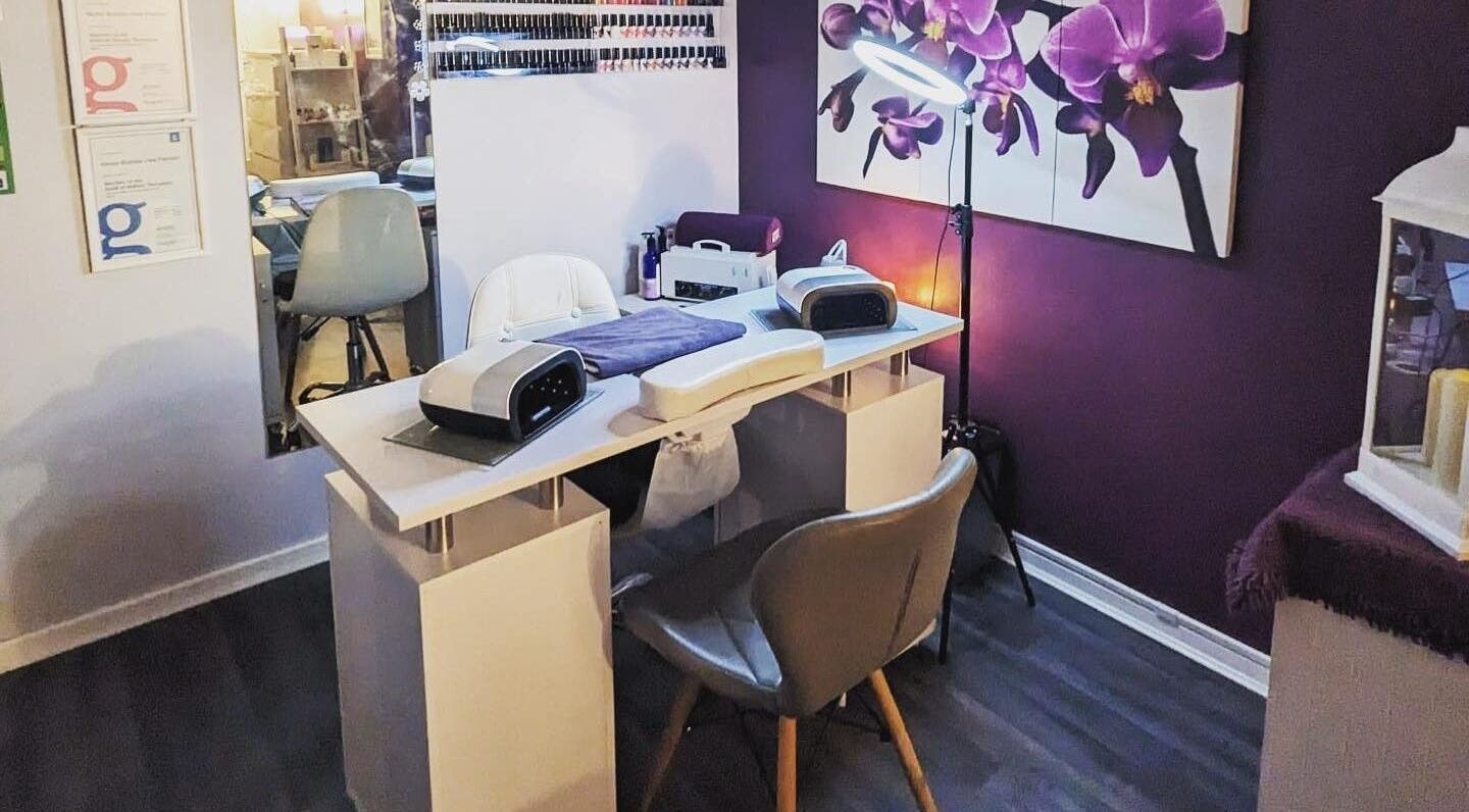 Stylish nail salon setup at Reflexions, Hockley, England, GB, featuring purple floral decor and modern equipment.