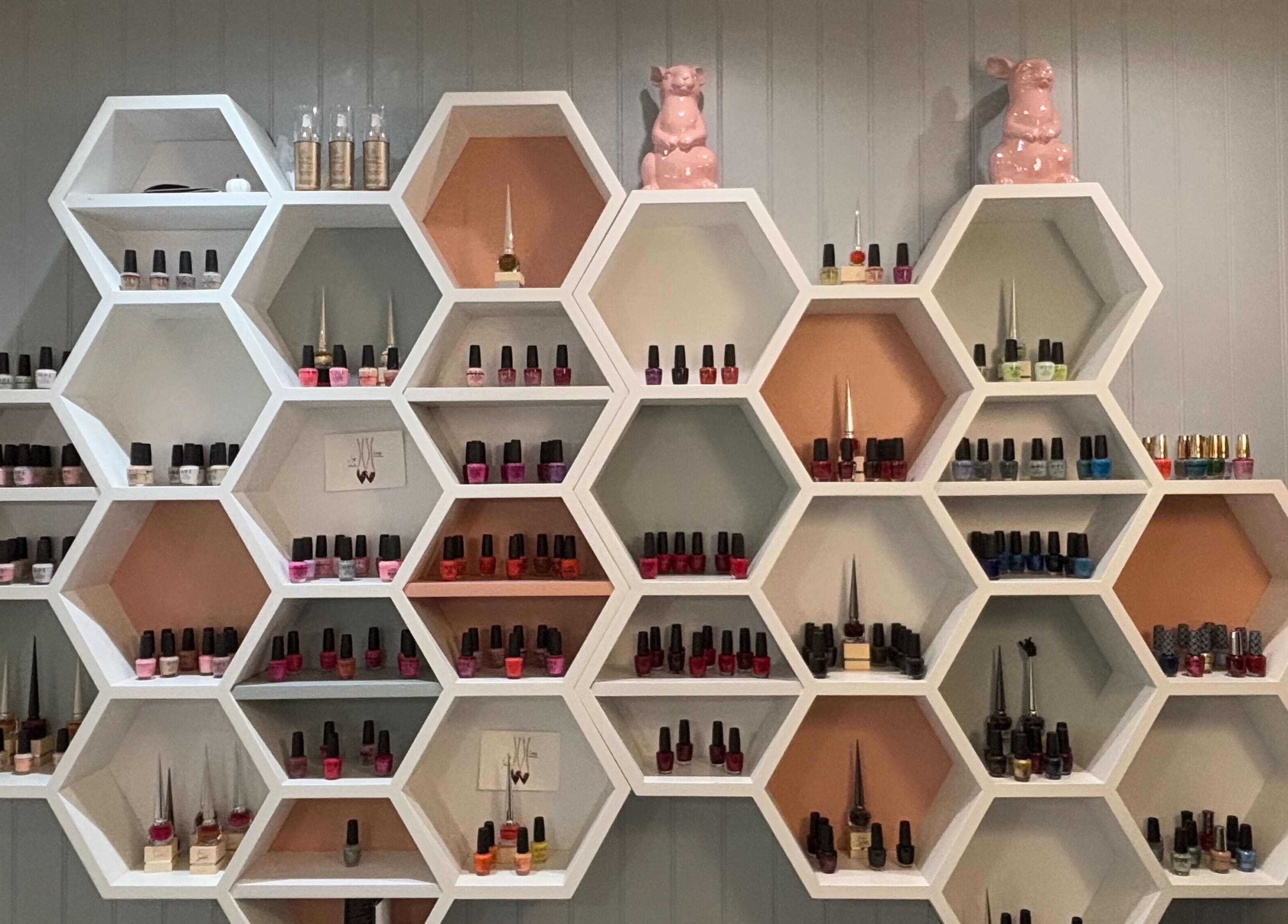Hexagonal shelves with nail polishes at Juju’s Beauty Salon, London, England, GB.