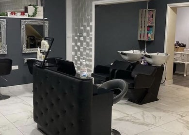Modern salon interior at Sharon O'Brien At Eclipse Hair and Beauty, Euxton, England, GB with sleek black chairs.