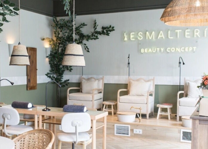 Interior de La Esmalteria Valdebebas en Madrid, Comunidad De Madrid, ES, con sillas acogedoras y decoraciones verdes.