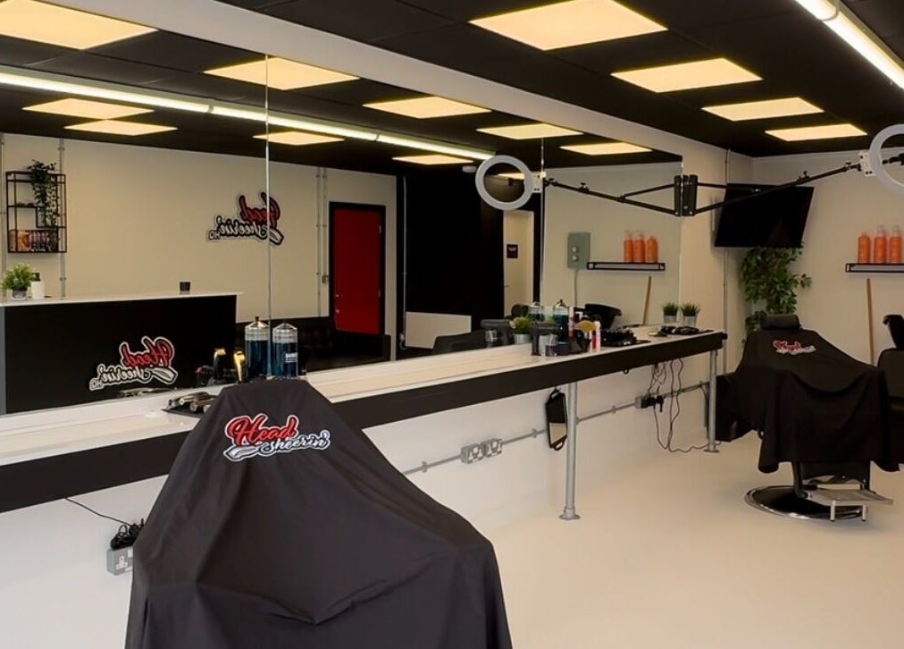 Modern salon interior at HeadsheerinHQ, Bridport, England, GB with sleek styling stations and decor.