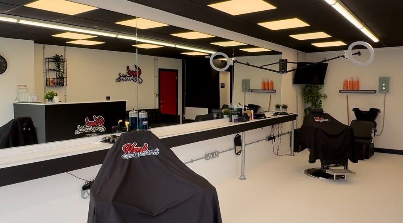 Modern salon interior at HeadsheerinHQ, Bridport, England, GB with sleek styling stations and decor.